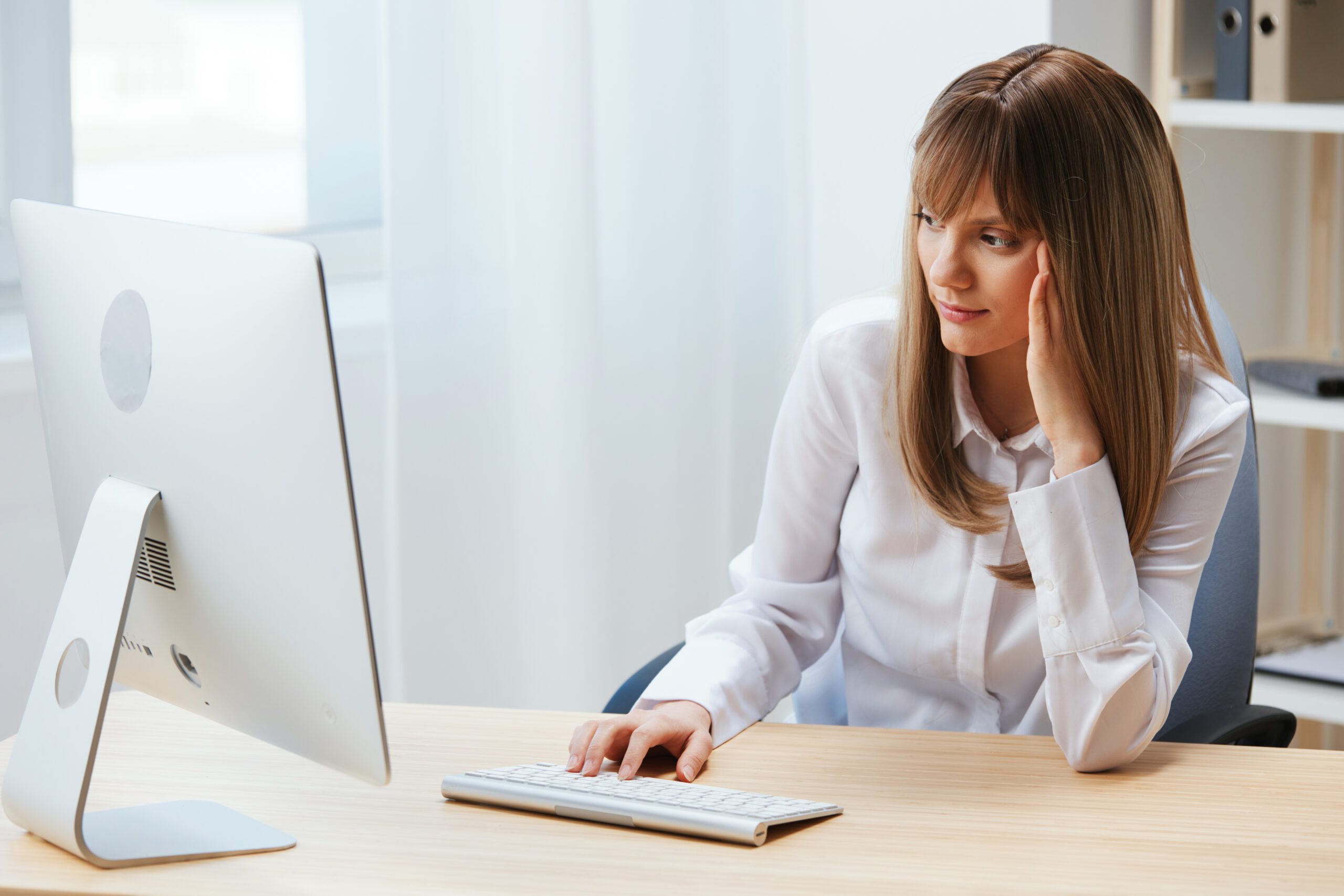 Focused adorable blonde businesswoman typing answer for client look at screen sitting at workplace in modern office. Concentrated employee work on computer online in support service. Copy space