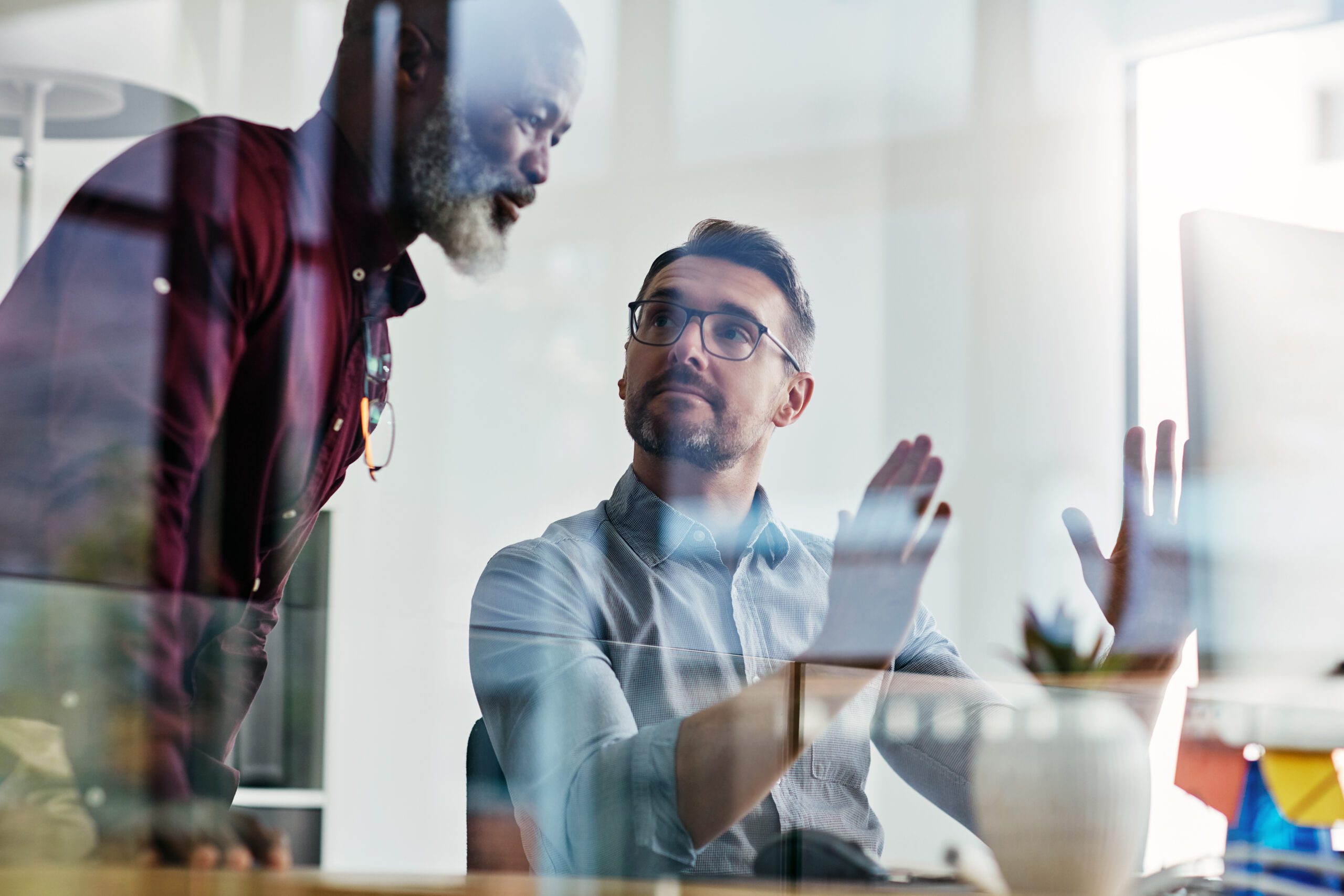 Business people, manager and collaboration on computer for advice, feedback or problem solving at tech company. Mature man and programmer explaining software for workflow solution, choice or decision.